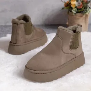Close-up of taupe platform snow boots featuring thick fur lining and elastic side panels