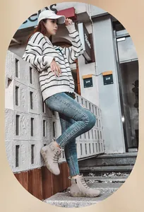Bottines Martin montantes beiges avec semelle ondulée style poulpe dans un décor de rue urbain