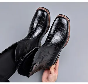 Close-up of retro black western cowboy boots with crocodile texture and embroidery