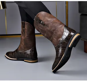 Close-up of retro brown men's cowboy boots with crocodile pattern and embroidery