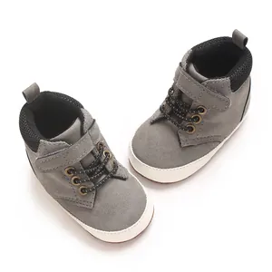 Vista de detalle superior de zapatos grises para bebés con suela blanca suave y blanda