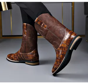 Detailed view of men's retro brown cowboy boots with embroidery and crocodile texture.