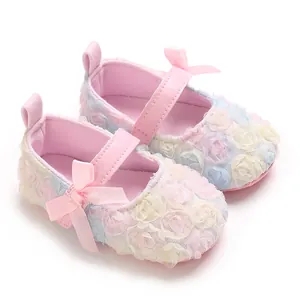 Detailed view of soft-sole baby Mary Jane shoes with pastel flowers and pink silk bows.