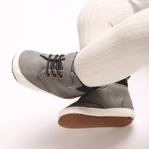 Primer plano de zapatos grises para bebés con suela blanda antideslizante y diseño alto