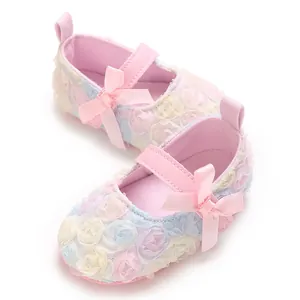 Close-up detail of baby Mary Jane shoes with 3D floral lace and pink satin bows