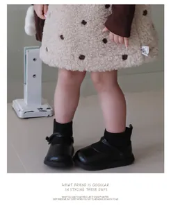 Vue rapprochée de bottines en cuir pelucheux pour fillettes avec semelles souples antidérapantes