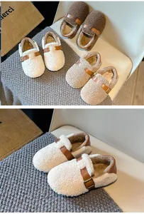 Detail view of cozy white fleece kids slippers with brown buckle strap.