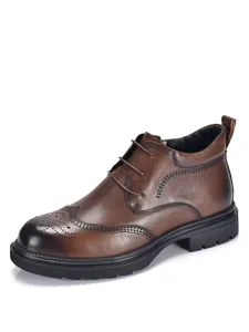 Detailed view of men's brown wingtip leather boots with classic brogue perforations