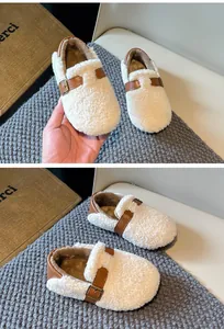 Detail of children's fleece loafers featuring soft woolly texture and brown buckles