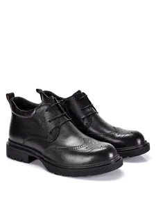 Detailed view of black genuine leather brogue boots for men with decorative perforations