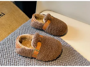Detail of children's brown shearling winter shoes with warm lining and buckle strap