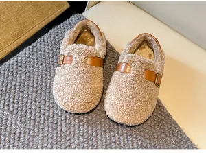 Close-up of cozy children's lamb wool shoes with decorative brown buckle strap.