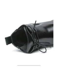 Detailed macro view of black leather men's Chelsea boot collar with laces and side zipper