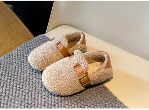Detail view of cozy beige children's fleece loafers featuring a decorative buckle strap