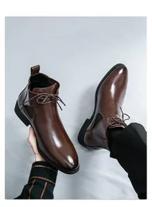 Detailed view of polished brown leather Chelsea boots for men with lace-up design.