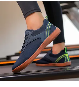 Vue latérale de chaussures de marche en flyknit bleu marine avec accents verts sur tapis