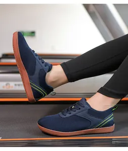 Gros plan de baskets en tricot bleu marine avec des accents vert fluo sur un tapis de course.