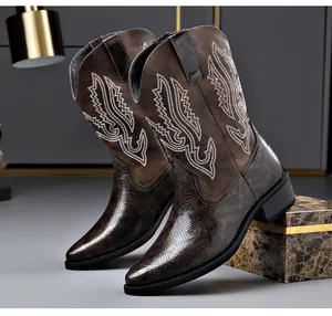 Nahaufnahme von braunen Vintage-Cowboystiefeln mit Stickerei und Schlangenhaut-Textur.