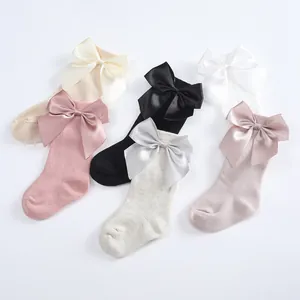 Elegant children's knee-high socks featuring large satin bows in various pastel colors.