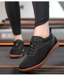Vue détaillée de chaussures de marche noires en maille respirante sur un tapis de course
