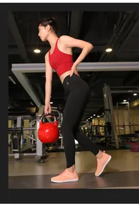 Chaussures de sport roses en maille portées par un mannequin dans une salle de gym.