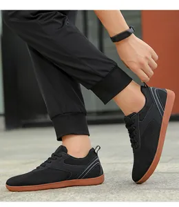 Détail de baskets de sport noires en maille respirante avec semelle en gomme marron.