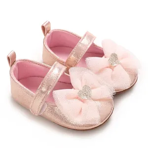 Detailansicht von rosa Glitzer-Babyschuhen mit Tüllschleife und silbernem Herz-Detail