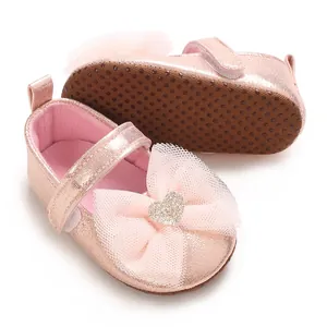 Detailansicht pinker Glitzer-Babyschuhe mit Netzschleife und rutschfester Sohle
