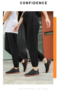 Couple portant des chaussures de sport flyknit noires marchant sur un trottoir urbain