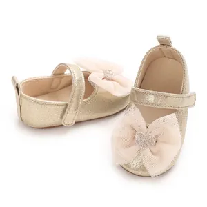 Nahaufnahme goldener Lauflernschuhe für Mädchen mit Tüllschleifen und Herzdekoren