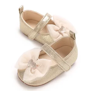 Detailansicht goldene Glitzer-Babyschuhe mit Herz-Schleife für kleine Prinzessinnen.