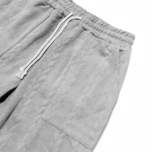 Detalle de pantalones de chándal grises para hombre con textura jacquard y cordón