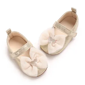 Detailansicht goldener Babylauflernschuhe mit rosa Netzschleife und Glitzerherz