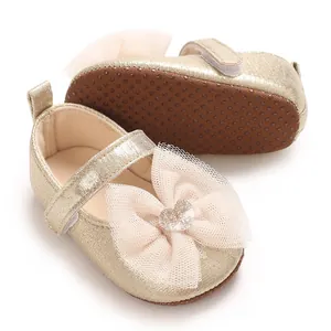 Detailansicht goldene Lauflernschuhe für Babys mit zarter Spitzenschleife und Herz.