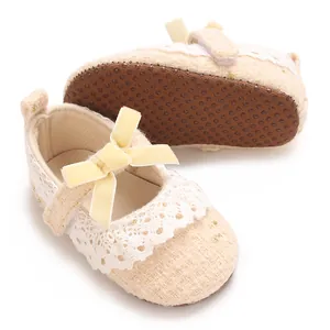 Detaillierte Nahaufnahme von beigen Baby Prinzessin Laufschuhen mit Spitze und Samtschleife