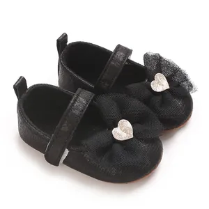 Detailansicht von schwarzen Baby-Lauflernschuhen mit eleganter Netzschleife und Goldherz.