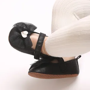 Nahaufnahme von schwarzen Prinzessinnen-Lauflernschuhen für Mädchen mit Herz-Schleifen.