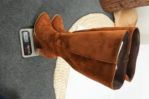 Brown suede knee-high boots with thick heels weighed on digital scale at 661.8g