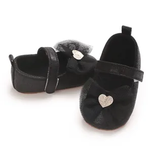 Nahaufnahme der schwarzen Babyschuhe mit Netzschleifen und Glitzerherzen
