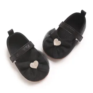 Nahaufnahme von schwarzen Baby-Prinzessin-Laufschuhen mit Spitzenschleife und Glitzerherz