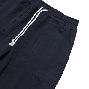 Detalle de pantalones deportivos jacquard azul marino con cordón blanco suave