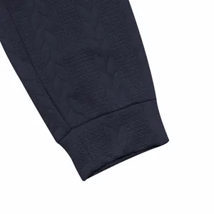 Primer plano detallado de la textura de punto jacquard azul marino en la manga del chándal de hombre