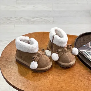 Detailansicht brauner Kleinkinder-Schneestiefel mit Plüschfutter und Pompon-Schleife