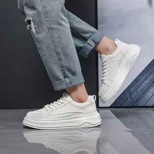 Zijaanzicht van witte leren sneakers met dikke zool gedragen met jeans