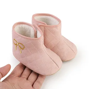 Soft pink quilted baby winter boots with warm fleece lining and cute yellow bow detail.