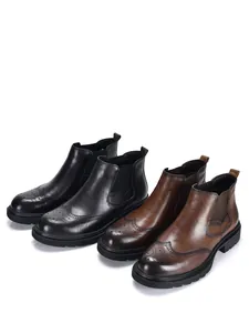 Paar schwarze und braune Herren-Chelsea-Boots aus Leder mit Wingtip-Brogue-Verzierung.