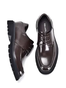 Detailed macro view of glossy dark brown leather Derby shoes with thick black lug soles