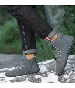Detail view of grey fur-lined snow boots for outdoor winter hiking on rocky terrain.