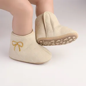 Close-up of beige quilted baby walker boots with yellow bow embroidery and anti-slip sole