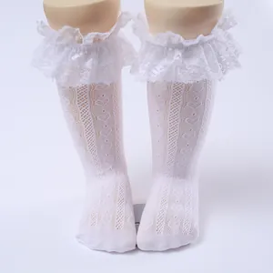 Close-up of white girls' lace ruffle knee-high socks with delicate mesh pattern